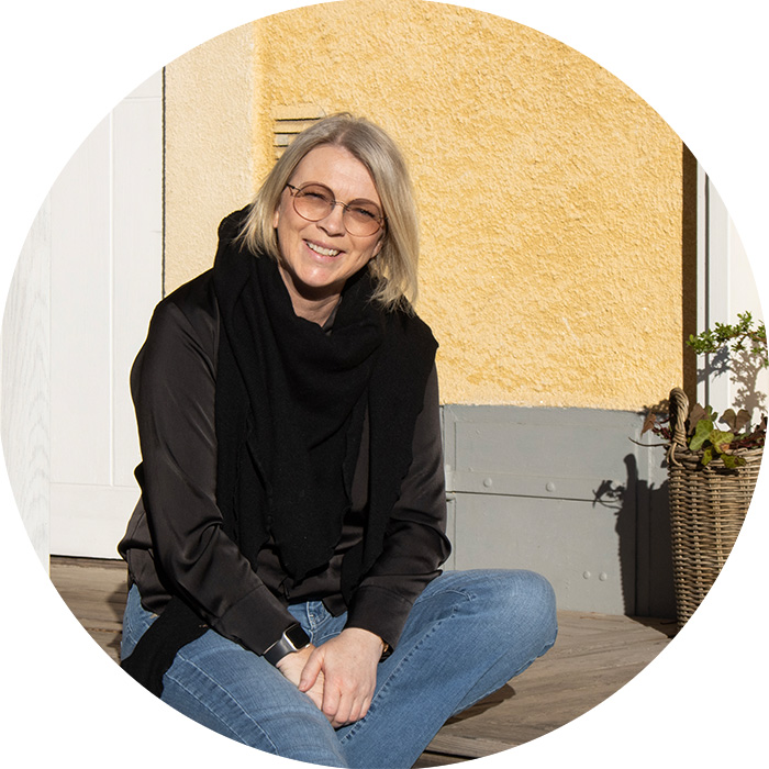 Jeanette Ragneby sitter på trappan utanför sitt hus.